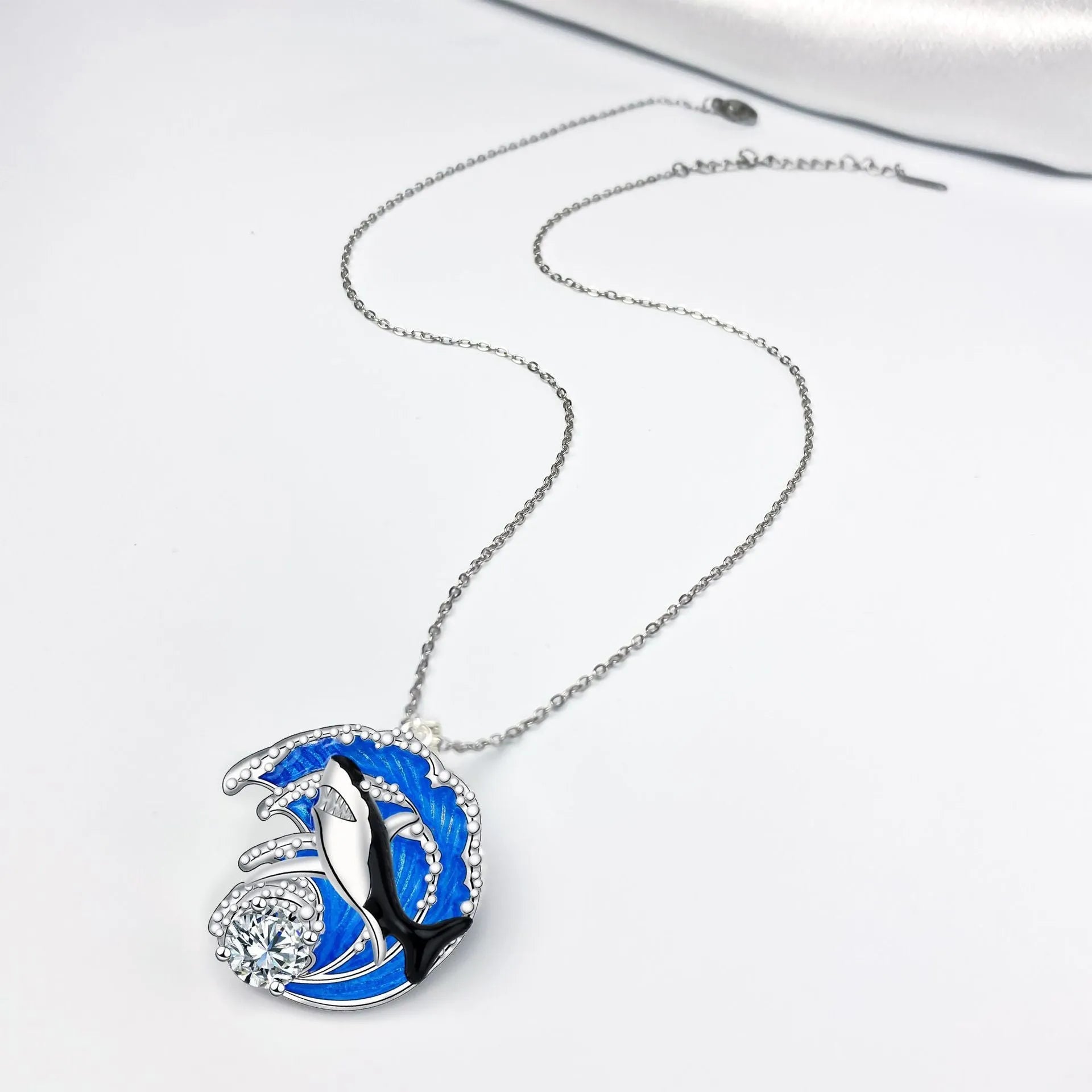 Close-up of a women's shark pendant necklace on a cross chain, showing detailed copper animal modelling.