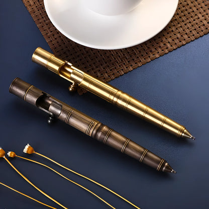 Brass tactical pen with press bolt mechanism showing cylindrical design and six ring details