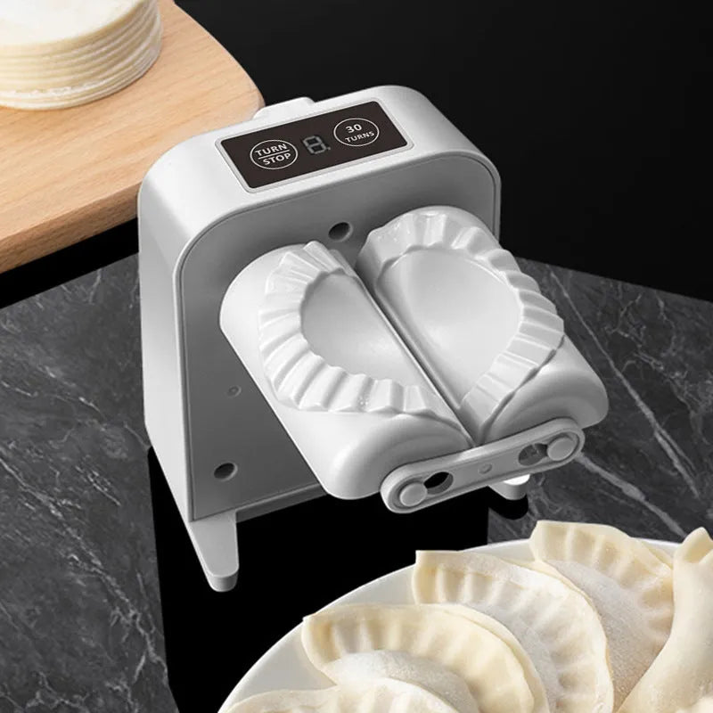 White automatic electric dumpling maker machine with USB cable, brush, and spoon.