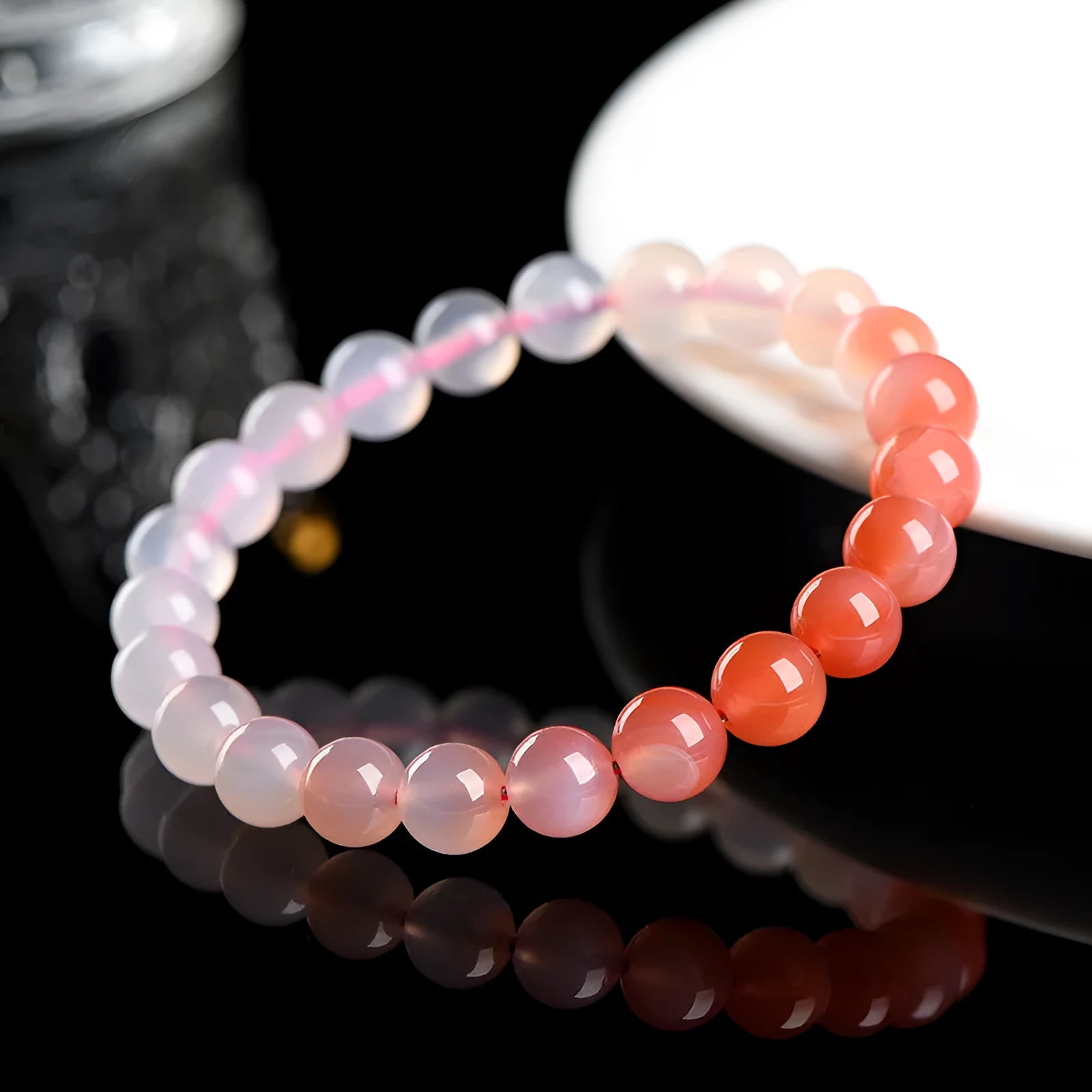 Natural gradient Yanyuan agate bracelet with geometric beads on a white background.