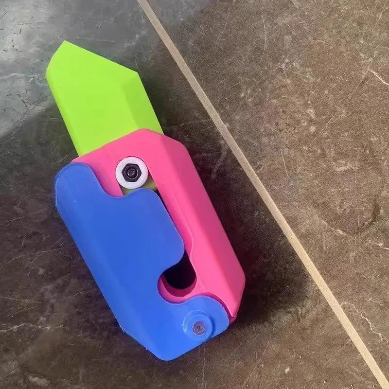 Small orange and green 3D printed plastic carrot knife fidget toy with blade extended.