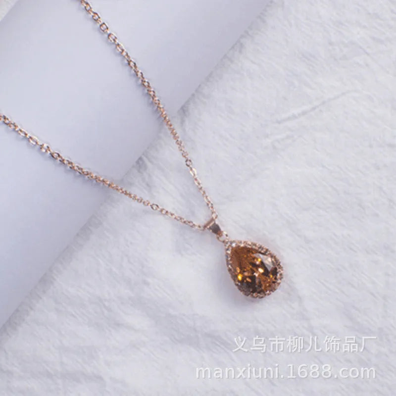 Rose gold geometric water drop pendant necklace on a model, showing adjustable chain and sparkling stone inlay.