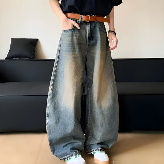 Man wearing retro blue distressed slim-fit jeans with a wide-leg cut.