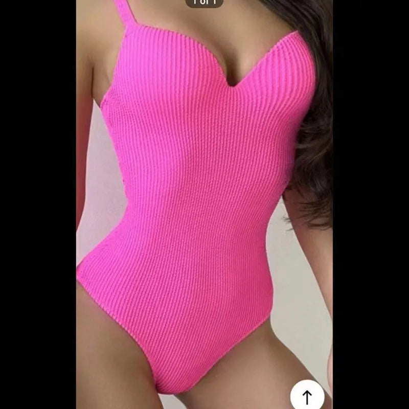 Women's black one-piece swimsuit with a sunken vertical stripe detail, shown on a model, featuring a sleeveless design.