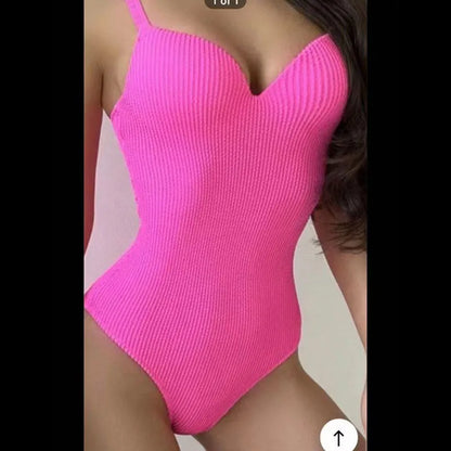 Women's black one-piece swimsuit with a sunken vertical stripe detail, shown on a model, featuring a sleeveless design.