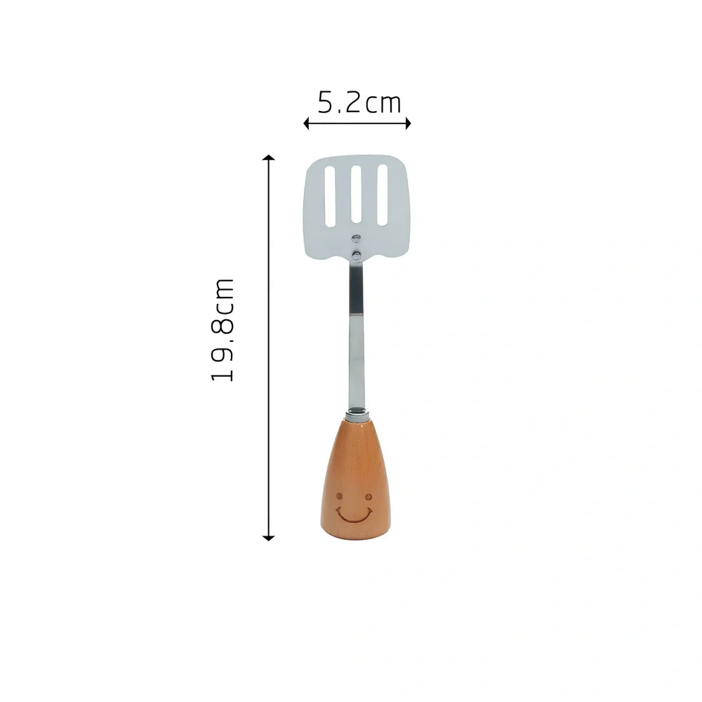 Twelve-piece stainless steel kitchen tools with beech handles and smiley motifs on a kitchen counter