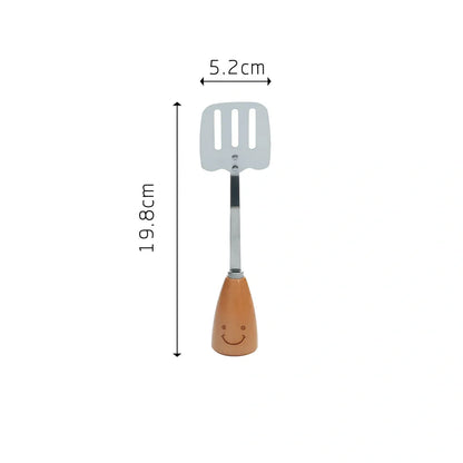 Twelve-piece stainless steel kitchen tools with beech handles and smiley motifs on a kitchen counter