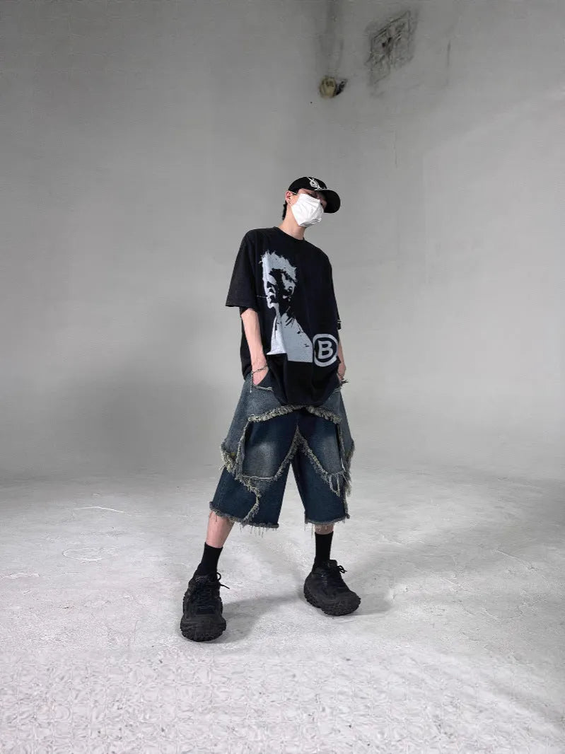 Blue men's loose-fit denim shorts with a frayed hem and a white five-pointed star patch on the leg.