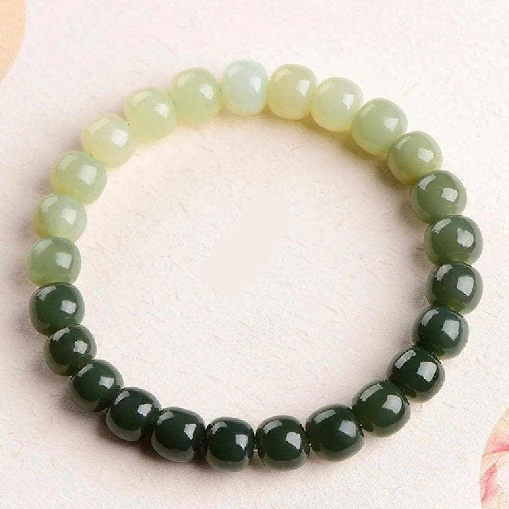 Natural Hetian jade bracelet showing gradient clear water colour on polished beads with either 6x7mm or 7x8mm dimensions