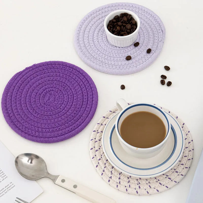 Set of three round grey cotton cord coasters, each 18cm in diameter, on a wooden table.