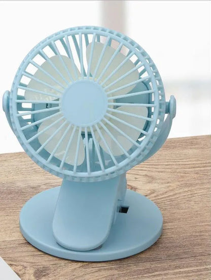 White USB rechargeable clip fan with plastic blades attached to a stroller handle.