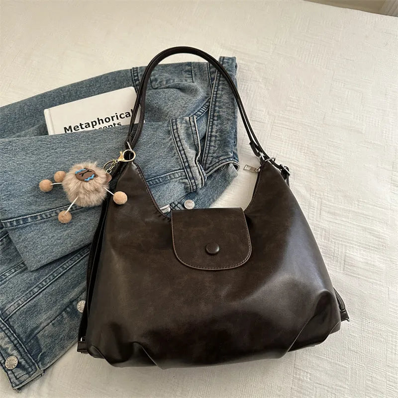 Textured PU leather women's shoulder bag in black with single strap and optional pendant