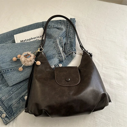 Textured PU leather women's shoulder bag in black with single strap and optional pendant