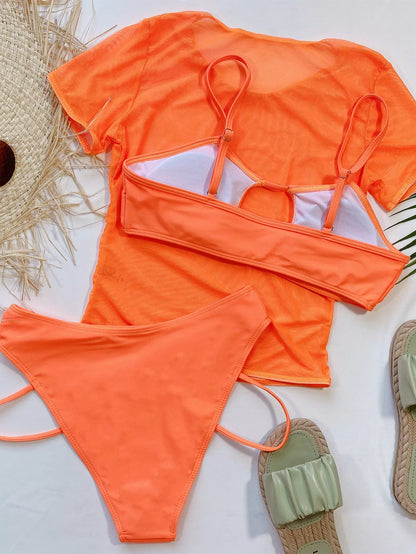 Orange high-waist ladies bikini three-piece set on a beach backdrop