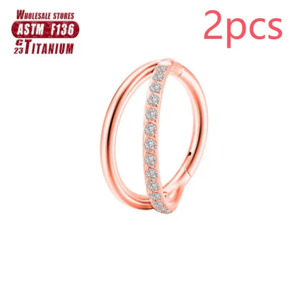 Pair of titanium alloy nose rings on a plain background showing silver, gold, black, and rose gold colour options.