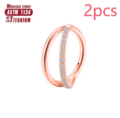 Pair of titanium alloy nose rings on a plain background showing silver, gold, black, and rose gold colour options.