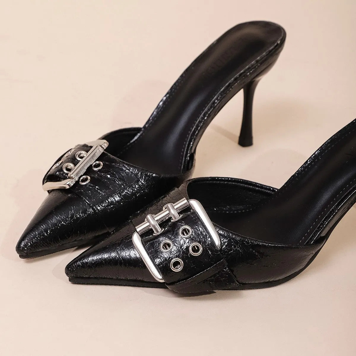 Black women's pointed toe high heel sandals with a decorative buckle on the front strap.