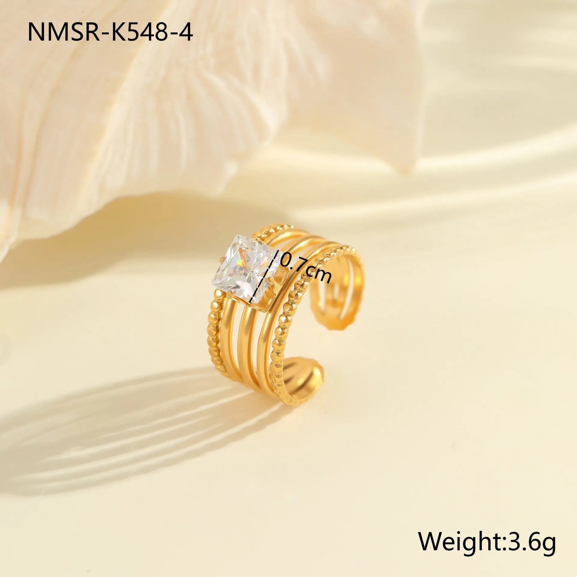 Gold electroplated stainless steel open mouth ring with geometric shapes and zircon inlay on a heart drop.