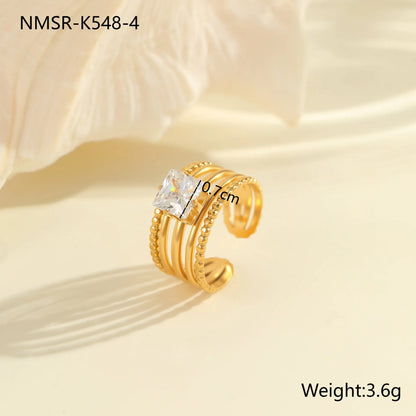 Gold electroplated stainless steel open mouth ring with geometric shapes and zircon inlay on a heart drop.