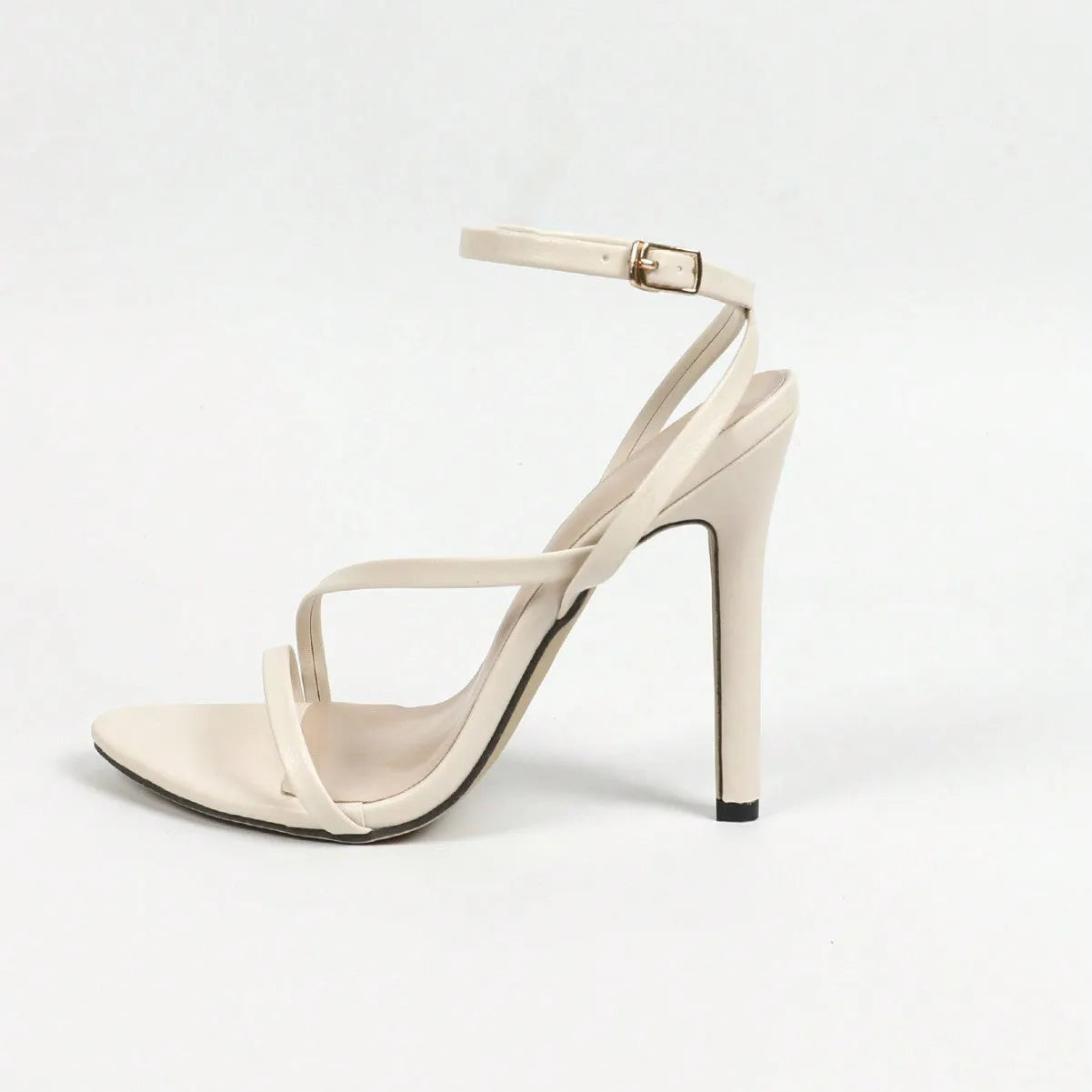 Women's gold high heels with round open toe, multi-stripe detailing, and cross ankle strap on beige background