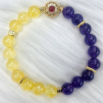 Handmade women's crystal bracelet in yellow and purple colours on a wrist.