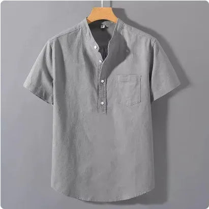 Man wearing a beige loose-fit linen blend casual shirt with a stand collar and short sleeves.
