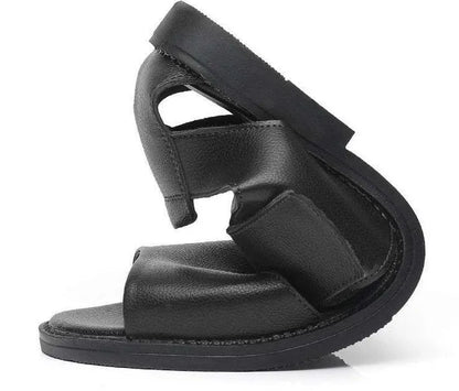 Men's brown leather Roman-style sandals with an open toe and a textured rubber sole on a wooden surface.