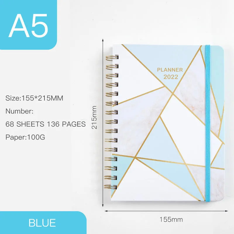 A5 spiral coil notebook open showing annual calendar pages and spiral binding