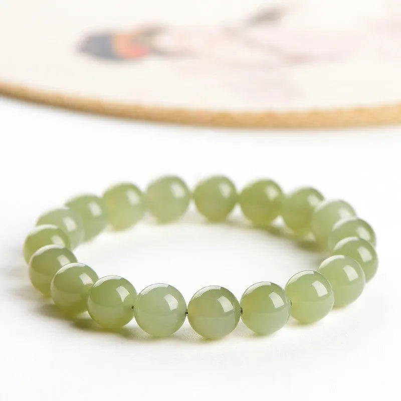 Hetian jade ball bracelet with polished spherical beads in ice-like clear water colours on wrist