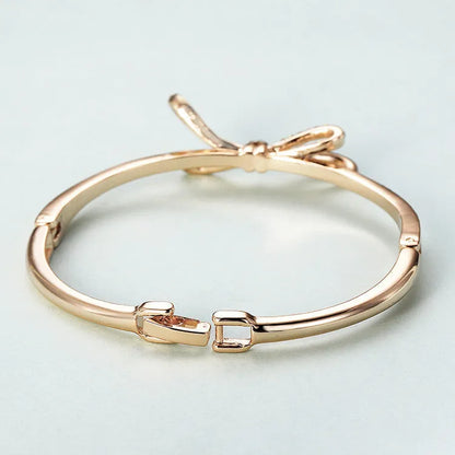 Women's rose gold alloy bracelet with bow design, diamond accent, and electroplated copper finish