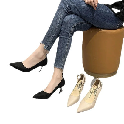 Women's black stiletto heels with skull pattern and ankle buckle closure on wooden floor