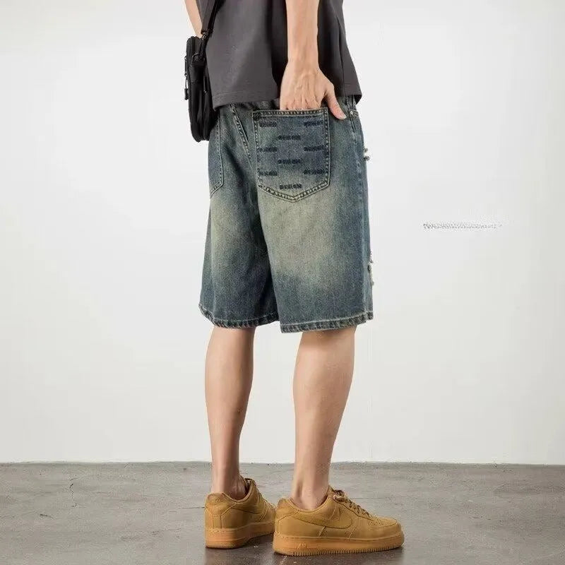 Men's blue distressed denim shorts with loose hole detailing and straight leg cut