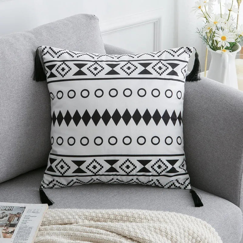Bohemian style decorative pillowcase in light grey colour on a sofa.