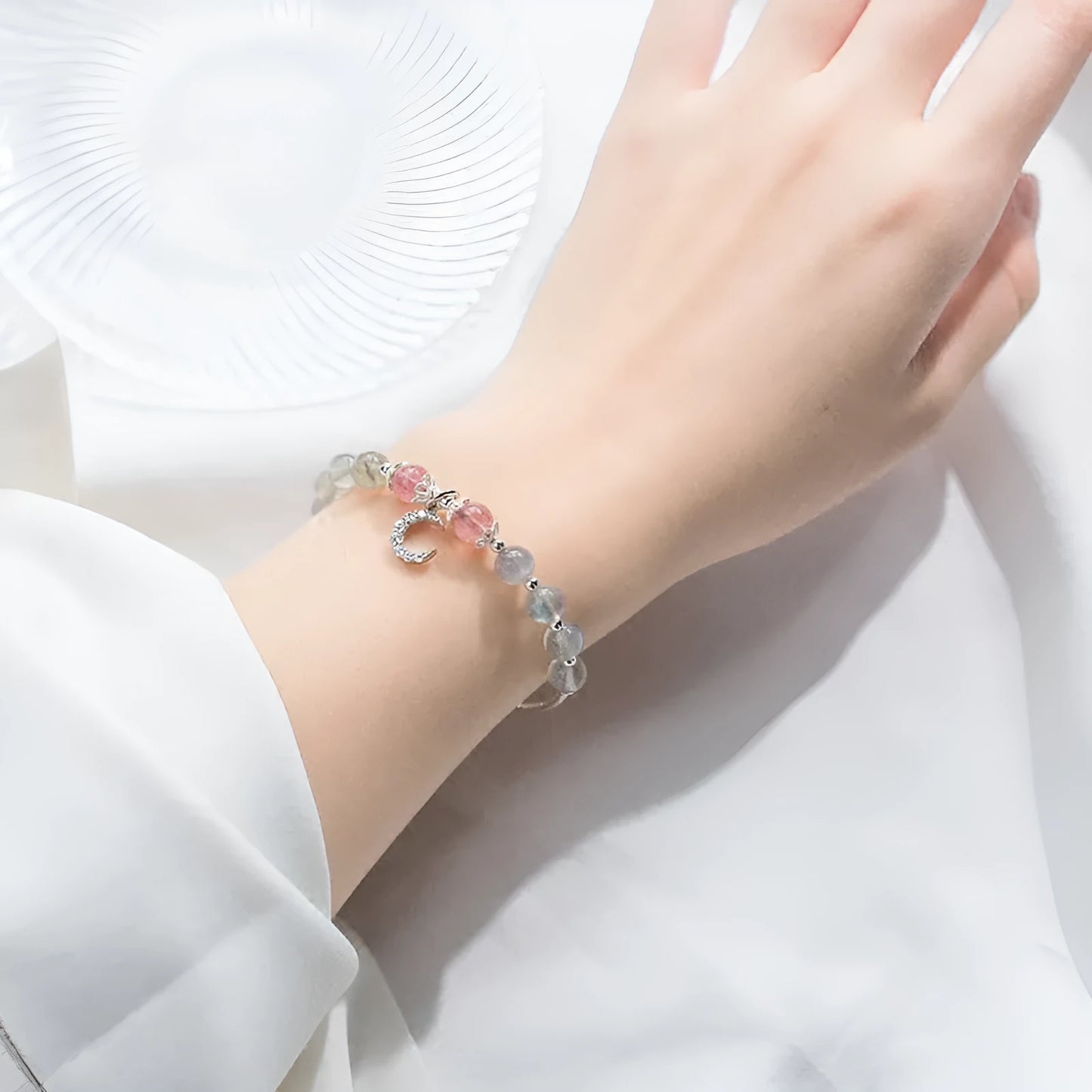 Natural moonlight-coloured moonstone bracelet with silver crescent moon charm on adjustable chain.