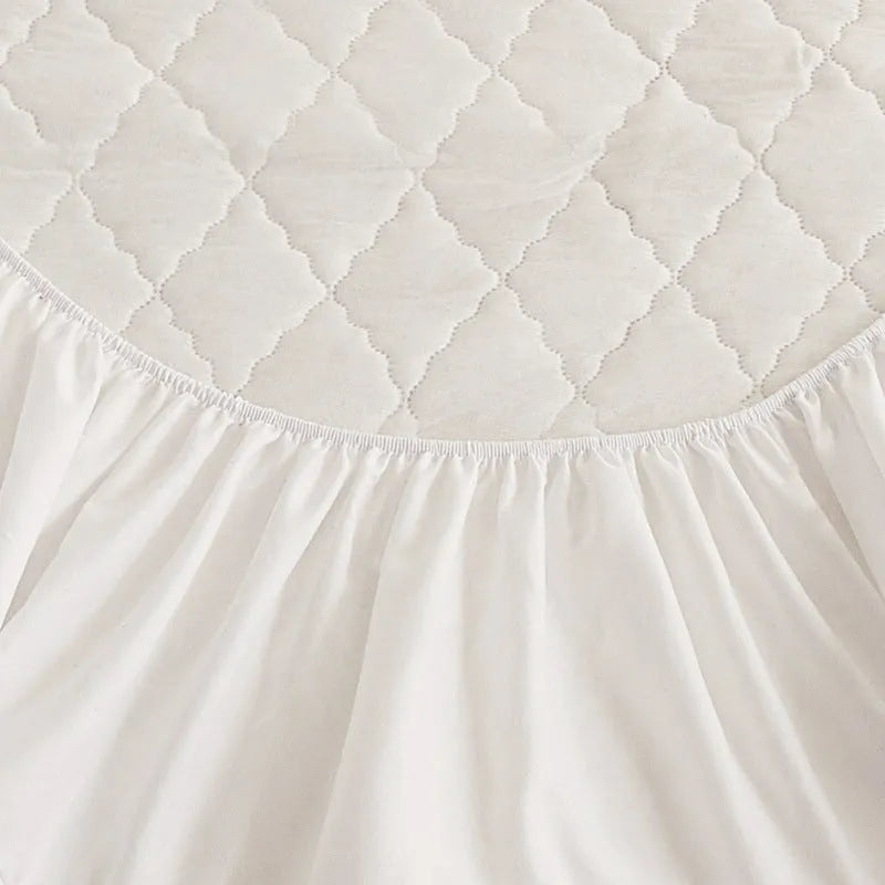 Diamond lattice quilted bamboo fibre mattress protector set in solid colour on a bed.