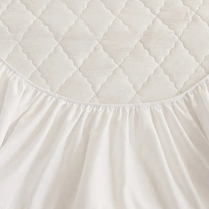 Diamond lattice quilted bamboo fibre mattress protector set in solid colour on a bed.