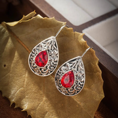 Pair of retro Bohemian carved drop earrings in red alloy for women, shown as a single pair