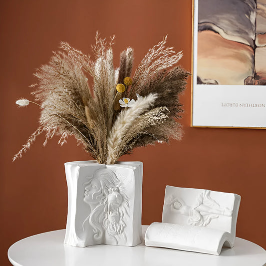 White ceramic book stand holding an open book at an angle, with a wire page holder in use.