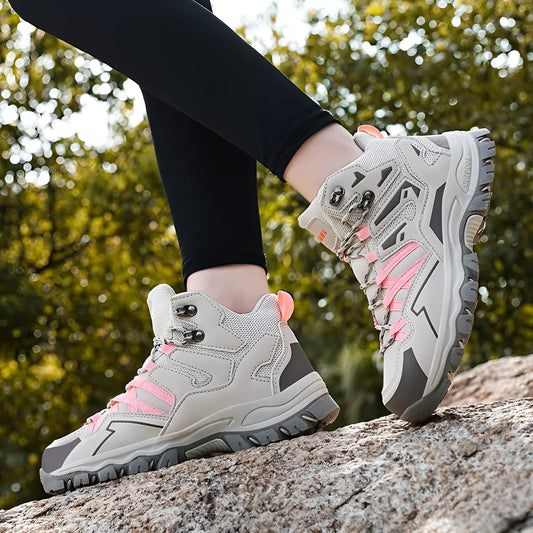 Low-top hiking sneaker in multiple colours on a rocky mountain path, showing lace-up front and rubber sole.