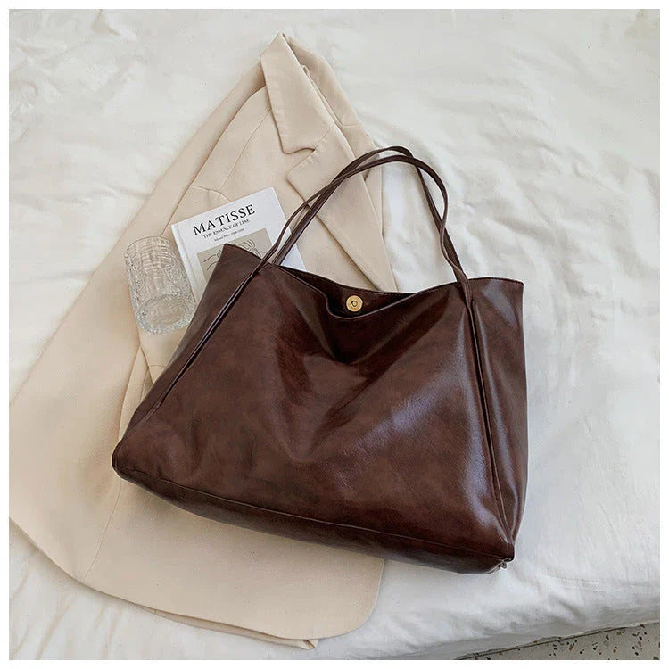 Stylish leather shoulder bag in various colors, including wine red, blue, black, brown, and beige. Showcases a versatile and spacious design for everyday use.