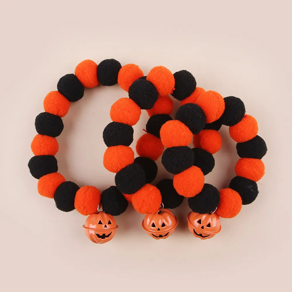 Orange pumpkin-shaped cat collar with a naughty cat face print, laid flat.