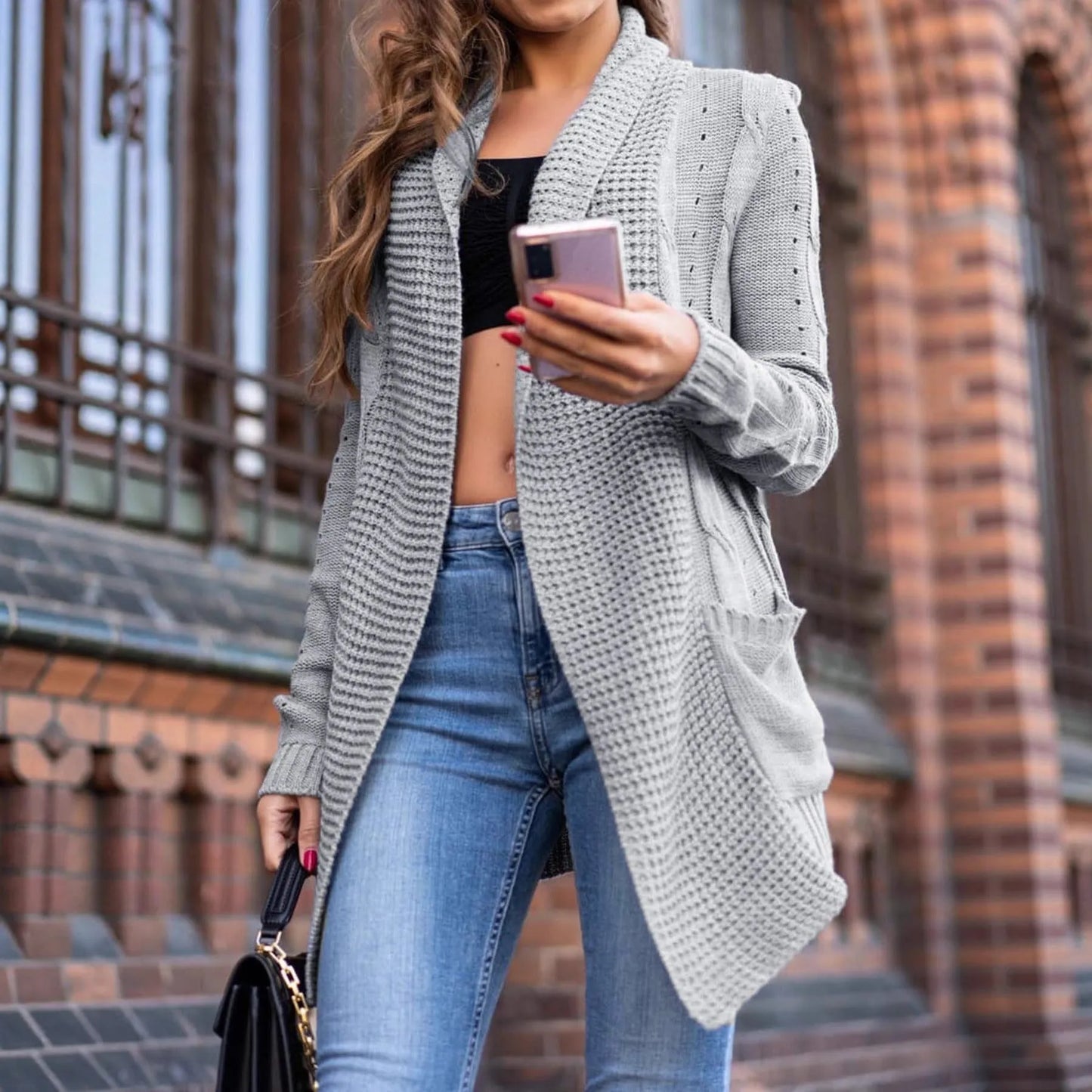 Grey loose fit women's cardigan coat with pockets and long sleeves on a hanger.