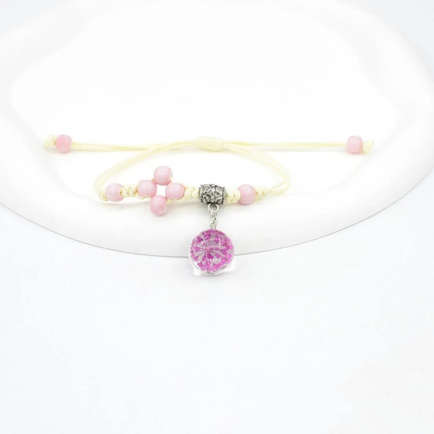 Hand-woven glass bracelet with large 1.4 cm beads containing real dried flowers, shown in blue.