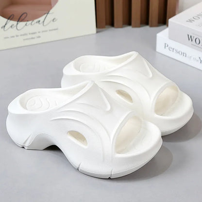 Women's thick-soled EVA foam beach slippers in rose red colour on a sandy background.