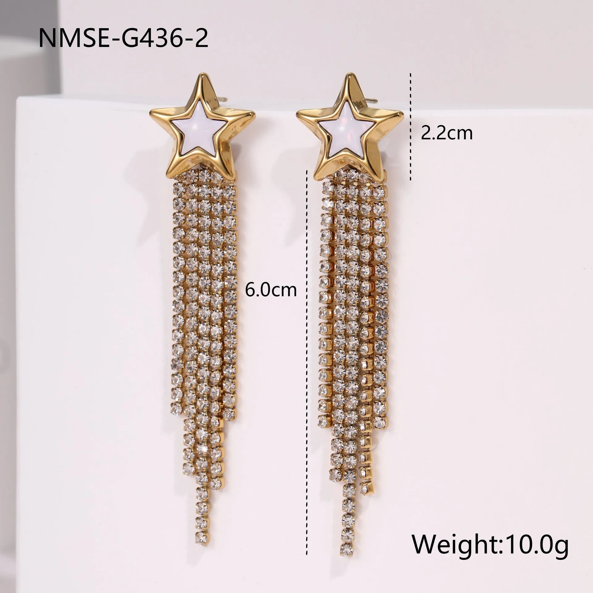 Gold-coloured women's earrings with a love heart shape, star details and dangling diamond-style tassels on a white background.