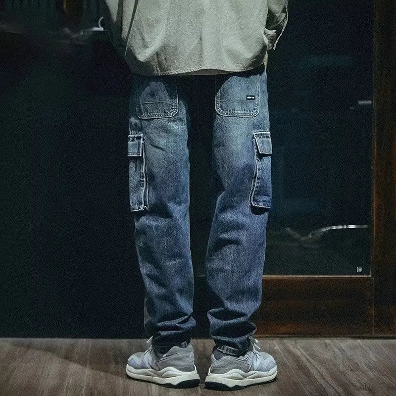 Men's blue loose straight leg jeans with a zip fly, shown on a model.