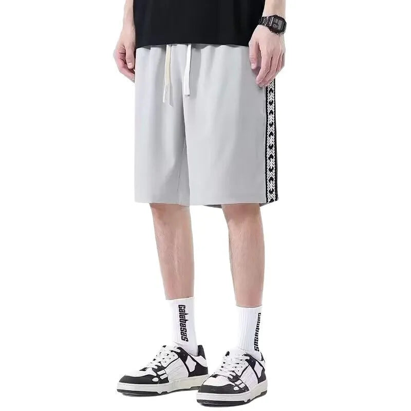 Man wearing loose-fit black baggy track pants with an elasticated waist for casual athletic wear