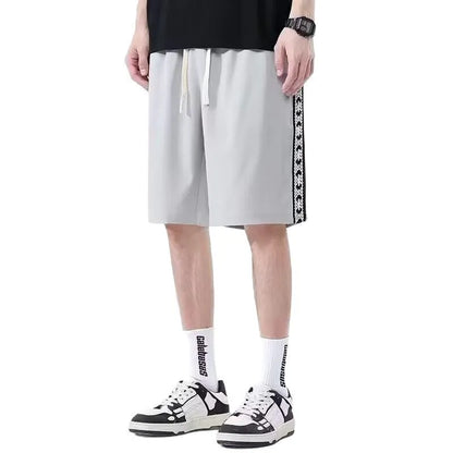Man wearing loose-fit black baggy track pants with an elasticated waist for casual athletic wear