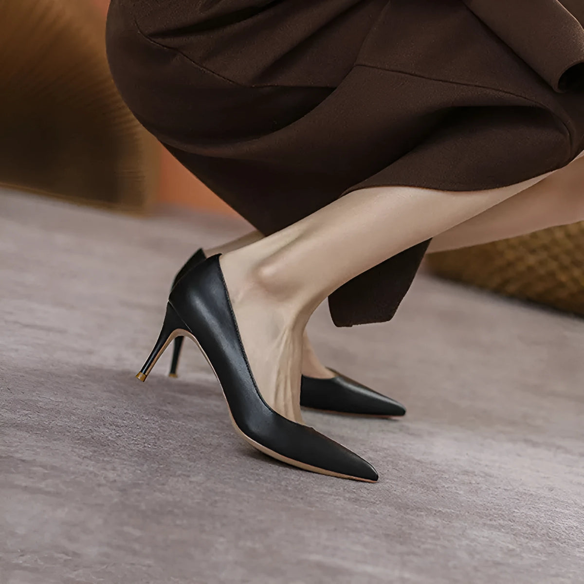 Black pointed toe stiletto high heel shoe with a low cut vamp on a white background.