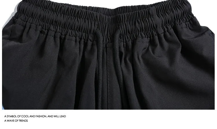 Men's black loose-fit quick-dry sports shorts with elastic waist, shown above the knee.